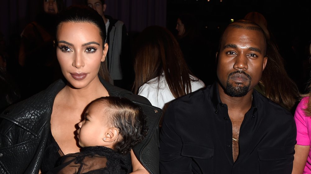 Kim Kardashian holding baby North and Kanye West