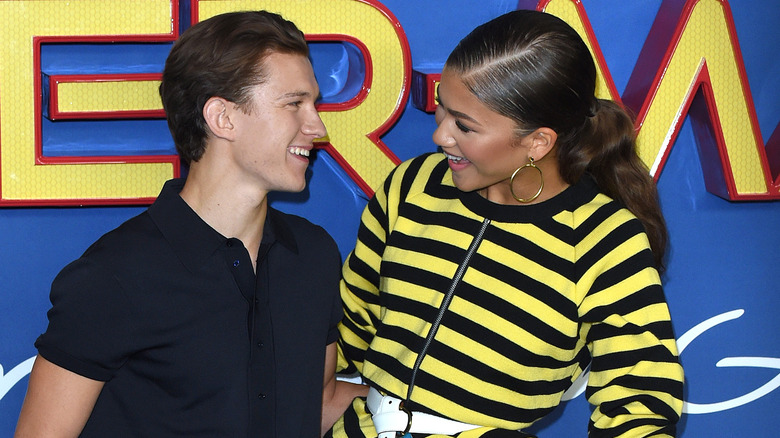 Tom Holland and Zendaya smiling at one another