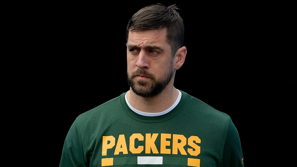 Aaron Rodgers in a Green Bay Packers t-shirt with a dark background 