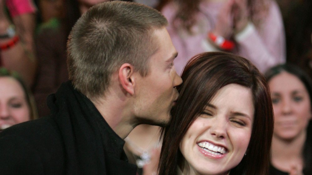 Chad Michael Murray kissing a smiling Sophia Bush's head