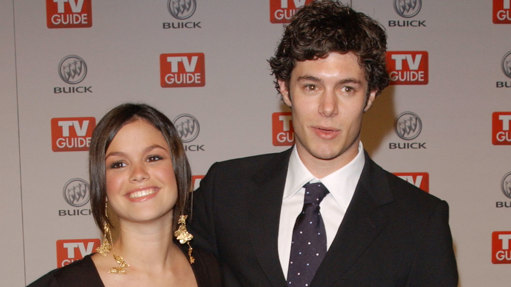 Rachel Bilson and Adam Brody smiling at a red carpet event 