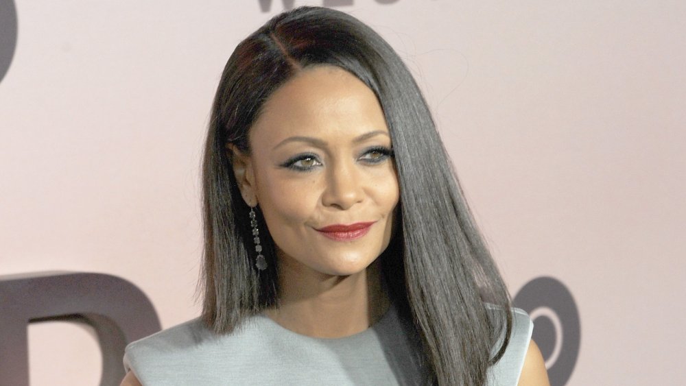 Thandie Newton in a silver dress, posing with a smirk at a Westworld premiere