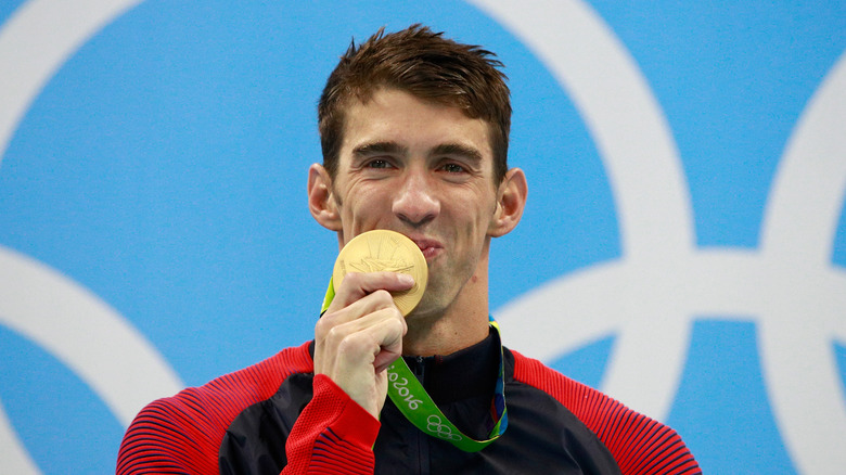 Michael Phelps kissing his gold medal