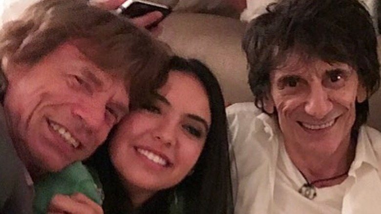 Mick Jagger hugging Noor Alfallah Keith Richards grinning