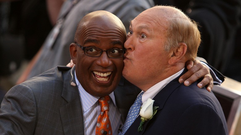 Al Roker and Willard Scott smiling and kissing on the cheek