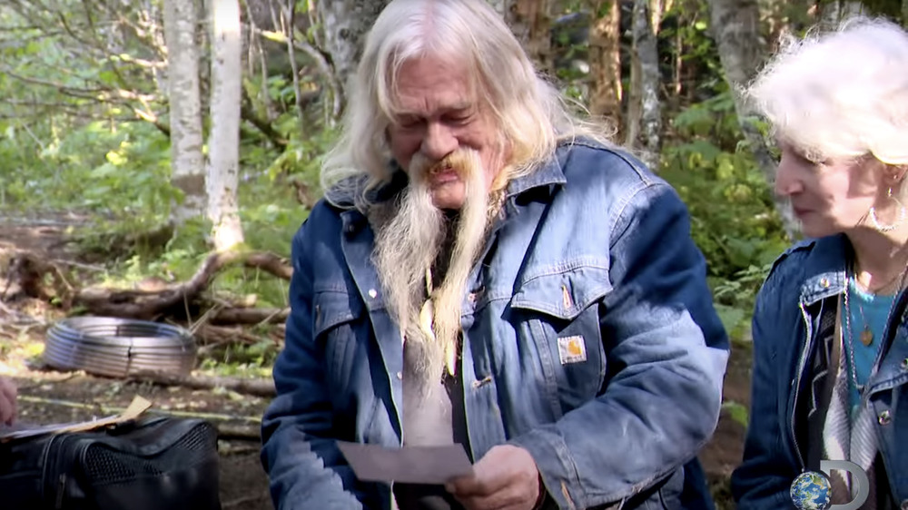 Billy Brown looking at pictures of his deceased family