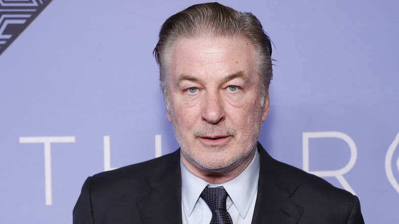 Alec Baldwin wearing a black suit