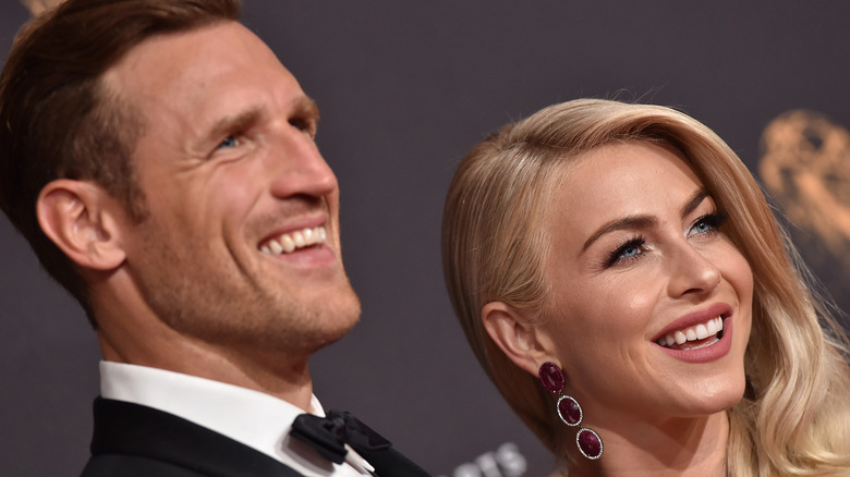 Brooks Laich and Julianne Hough smile from an angle on the red carpet