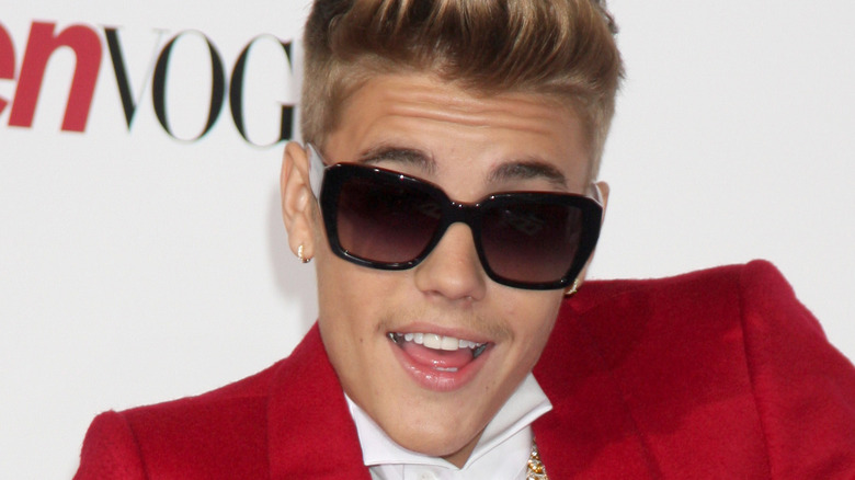 Justin Bieber in black sunglasses and red jacket 