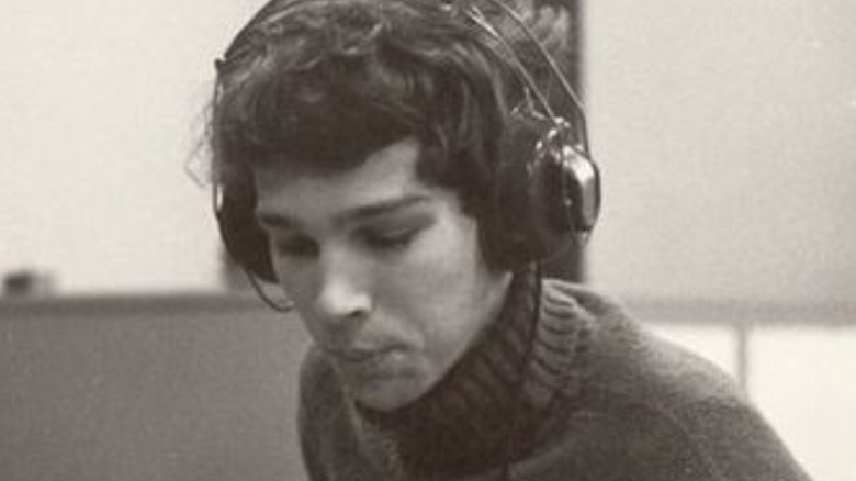 Chris Bell looking down, wearing headphones