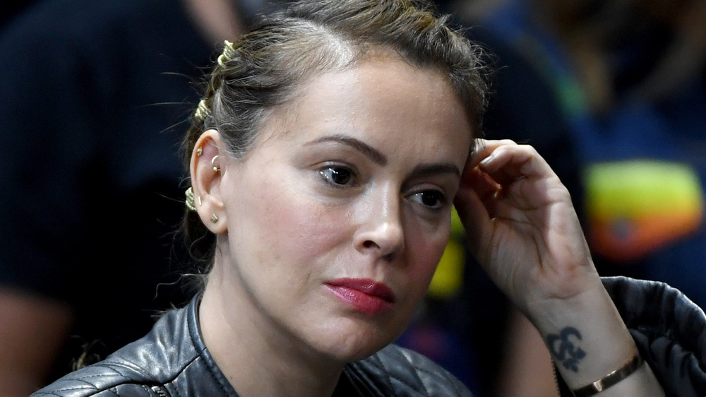 Alyssa Milano fixes her hair at a sports game