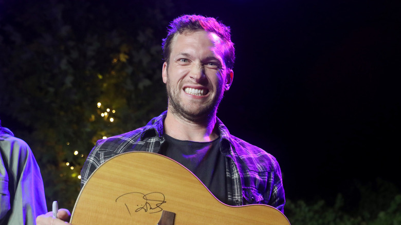 Phillip Phillips smiling with a guitar