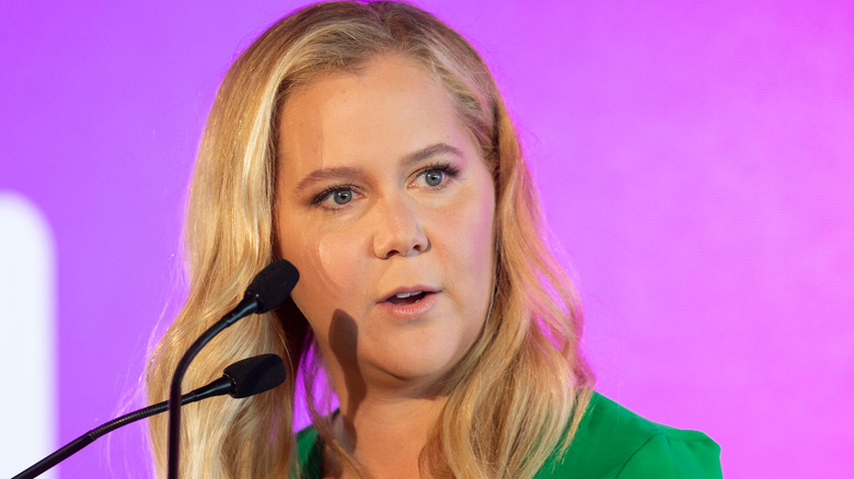 Amy Schumer speaks into a microphone