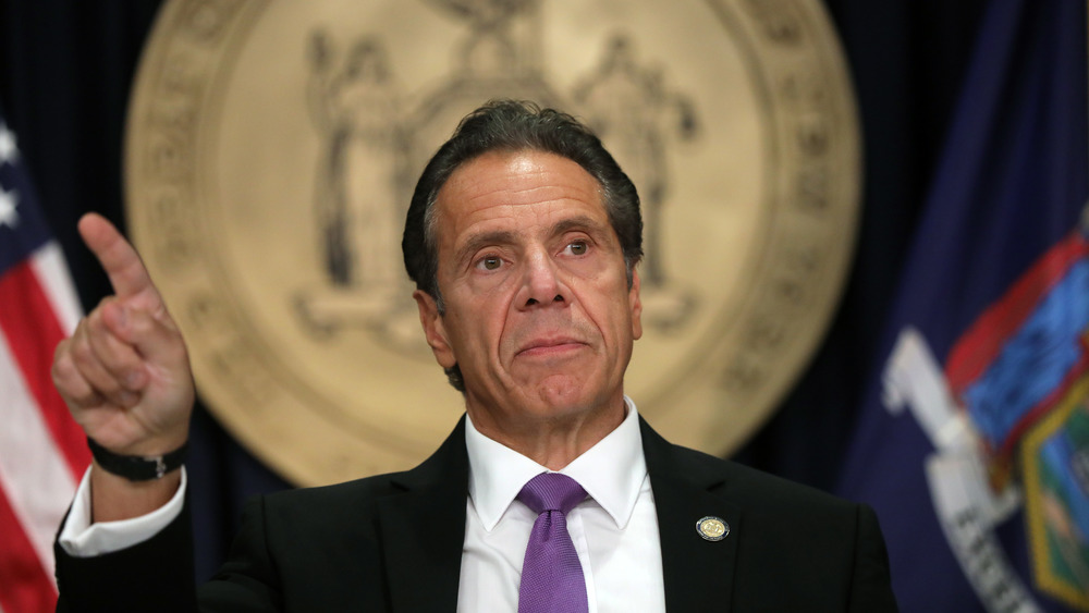 Andrew Cuomo gives a stern look while speaking with reporters