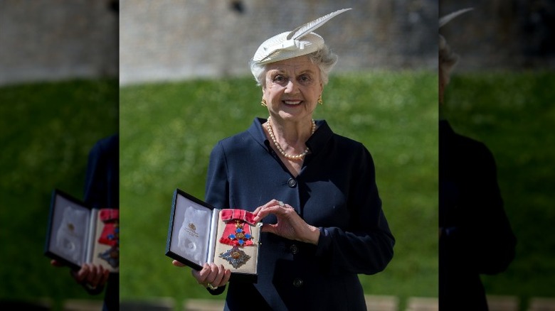 Angela Lansbury posing with her DBE medal