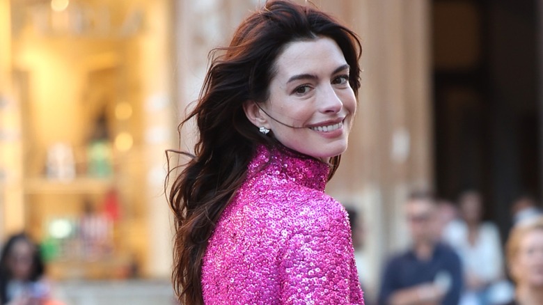 Anne Hathaway smiling in sequined hot pink top