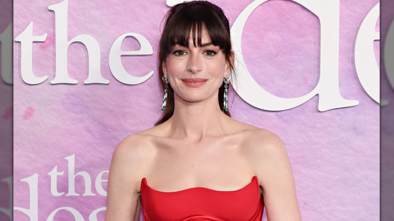 Anne Hathaway posing in a red Versace dress