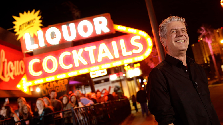 Anthony Bourdain stands outside bar