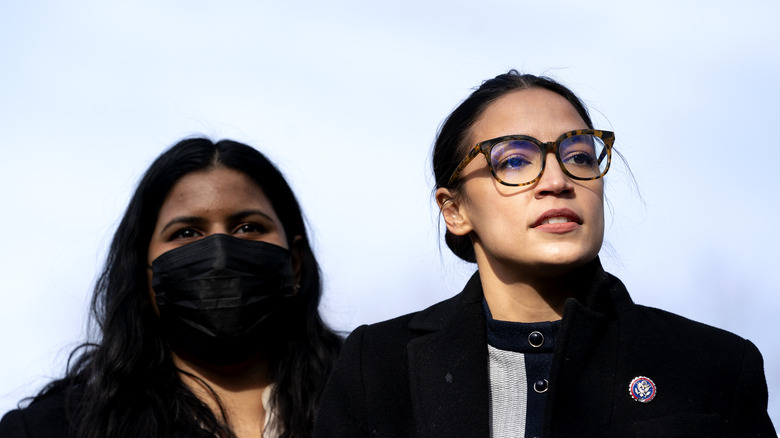 AOC at a podium in glasses