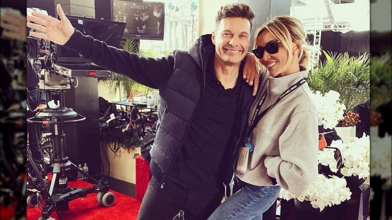 Ryan Seacrest posing with Giuliana Rancic