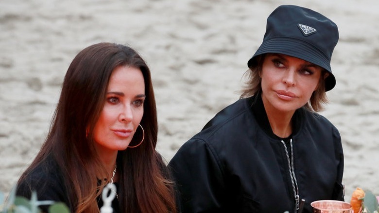 Kyle Richards and Lisa Rinna sitting on the beach in an episode of RHOBH