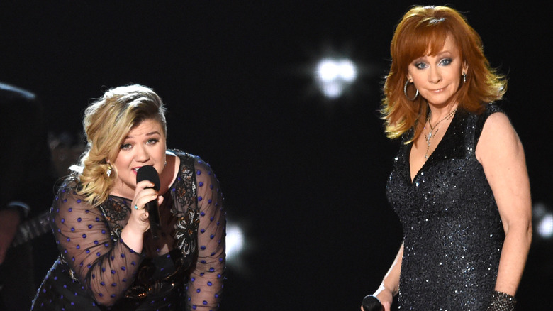 Kelly Clarkson sings with Reba McEntire on stage