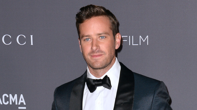 Armie Hammer wearing a dark blue tuxedo with black bowtie