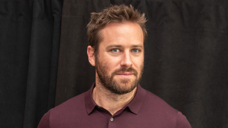 Armie Hammer wearing a maroon collared shirt