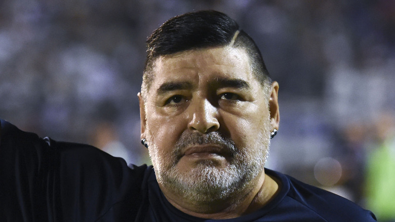 Diego Maradona standing at a soccer match
