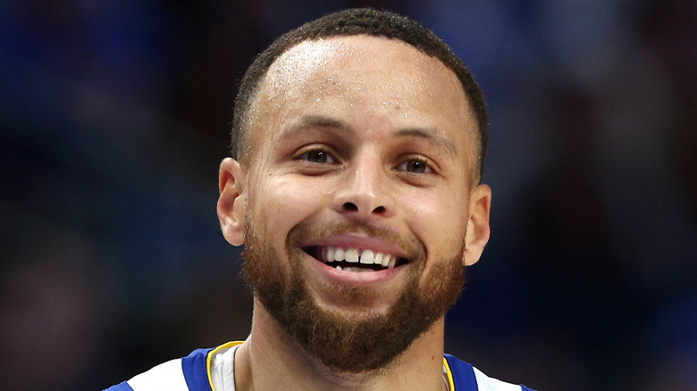 Stephen Curry playing in the NBA, smiling