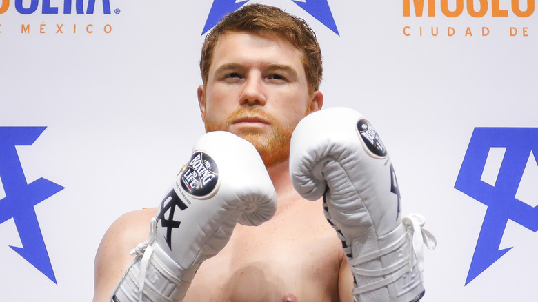 Canelo Álvarez posing with white boxing gloves