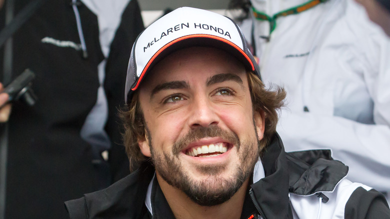 Fernando Alonso smiling, looking up