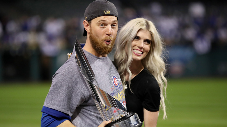 Ben Zobrist and Julianna Zobrist posing with the World Series trophy