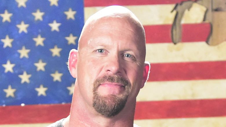 Steve Austin smiling in front of American flag