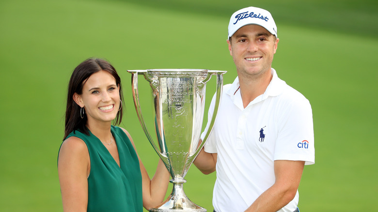 Justin Thomas and Jillian Wisniewski holding trophy