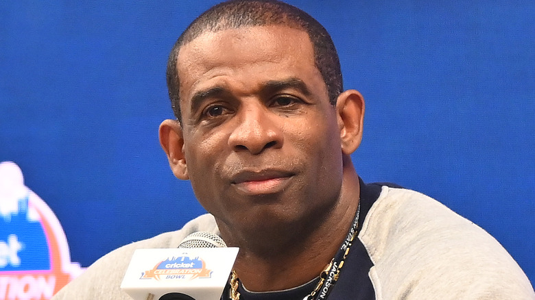 Deion Sanders posing near a microphone