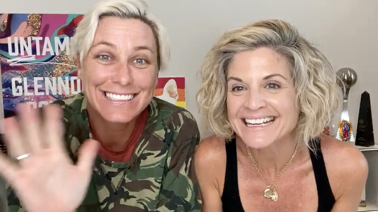 Abby Wambach and Glennon Doyle, smiling and waving