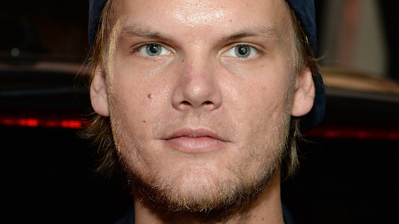 Avicii poses in a navy cap. 