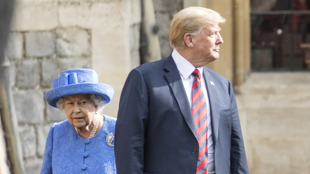 Donald Trump walks in front of the queen during UK visit