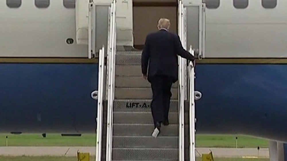 Donald Trump boarding Air Force One with what appears to be toilet roll on his shoe