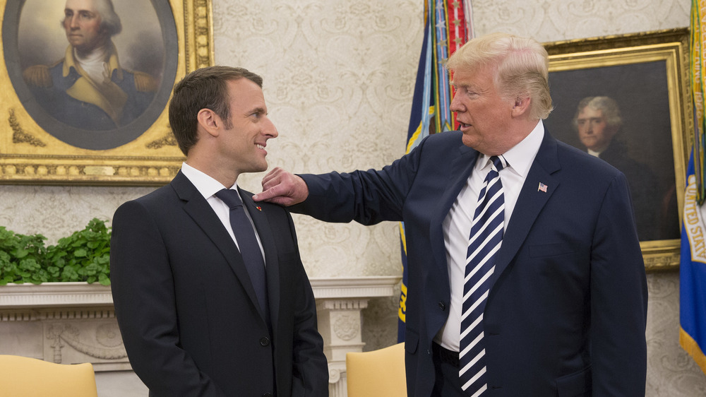 Trump jokingly brushes dandruff off Macron's shoulder