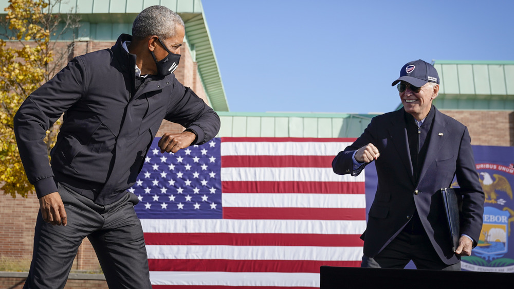 Barack Obama and Joe Biden air-bumping elbows at a campaign rally