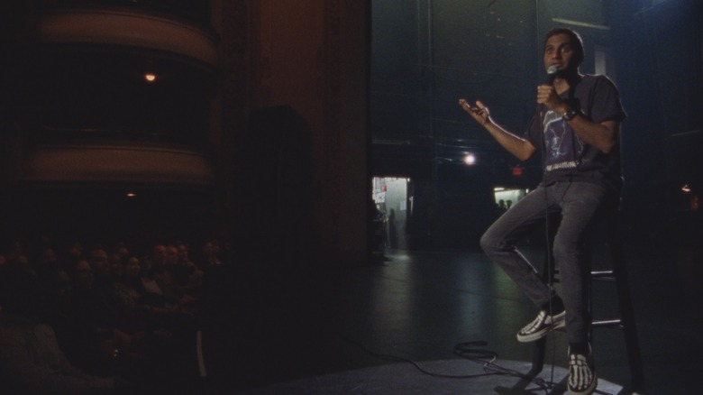 Aziz Ansari seated and performing stand up