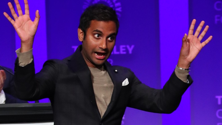 Aziz Ansari with hands up, speaking