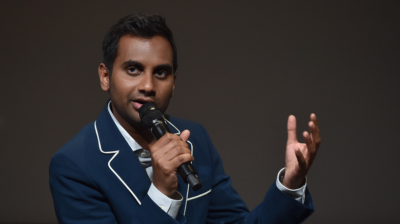 Aziz Ansari speaking into microphone