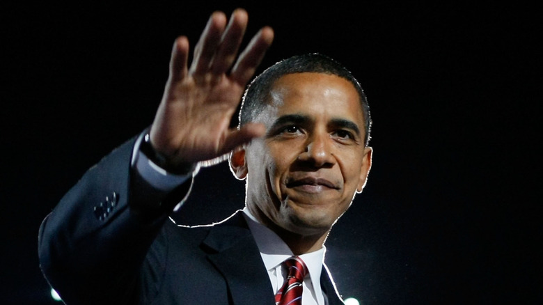 Barack Obama with his hand up