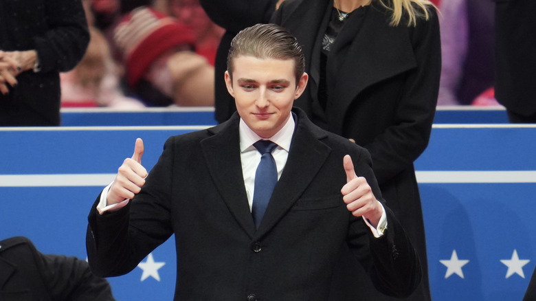 Barron Trump gesturing to the crowed at an indoor inauguration parade at Capital One Arena