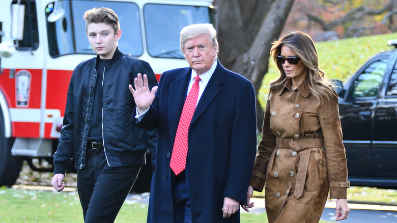 Barron Trump, Donald Trump and Melania Trump walk on the White House lawn