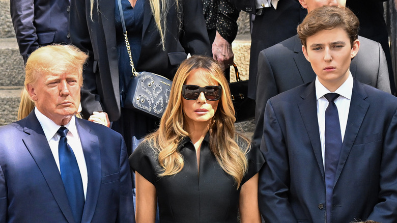 Donald, Melania, and Barron Trump somber