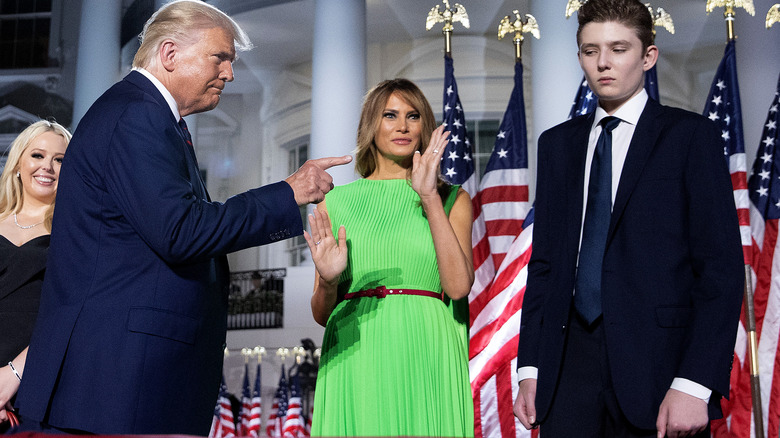 Donald Trump pointing at Barron Trump with Melania in the background